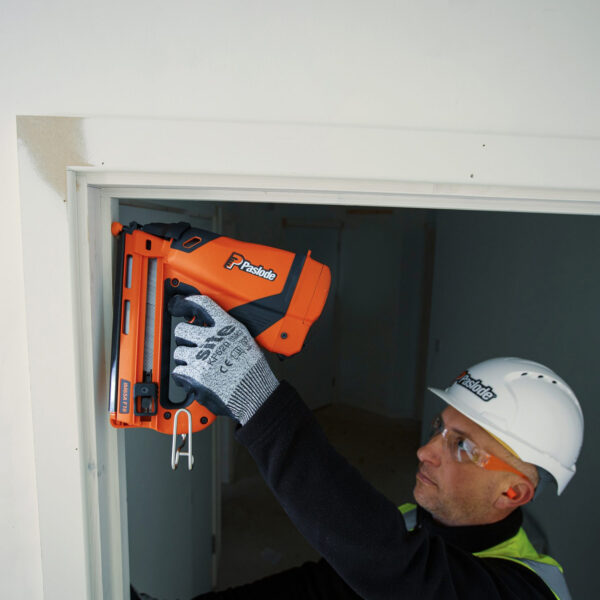 Carpenter fixing door jambs with a Paslode IM65A Nail Gun
